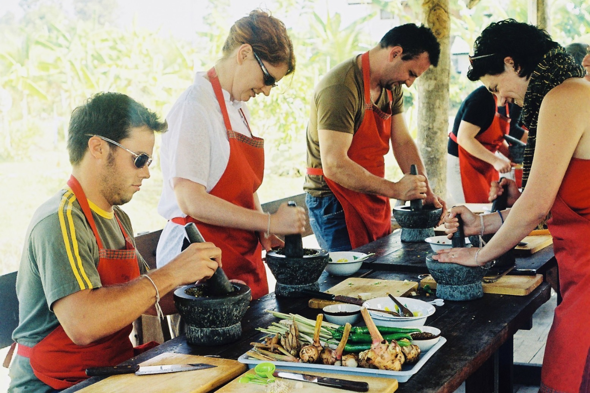 Tourists preparing traditional Thai dishes during a cooking class